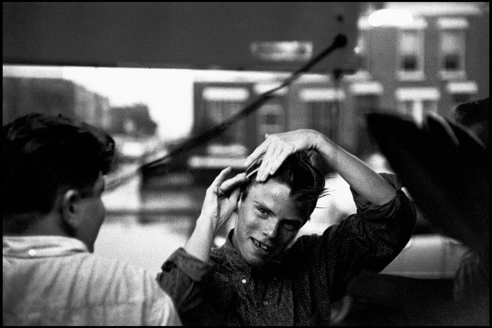 Bruce Davidson. Бенжи расчесывает волосы у витрины кондитерской. 1959