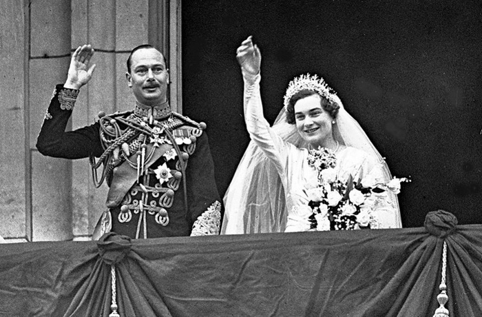 Герцог и герцогиня Глостера машут толпе с балкона Букингемского дворца в Лондоне после свадебной церемонии 6 ноября 1935 года. (AP Photo)