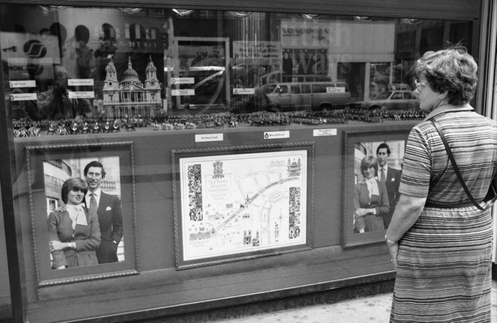 Женщина любуется витриной с выставкой фотографий королевской свадьбы на Пятой Авеню в Нью-Йорке 27 июля 1981 года. В витрине были выставлены фотографии принца Чарльза и леди Дианы Спенсер и игрушечные солдатики. (AP Photo/Marty Lederhandler)