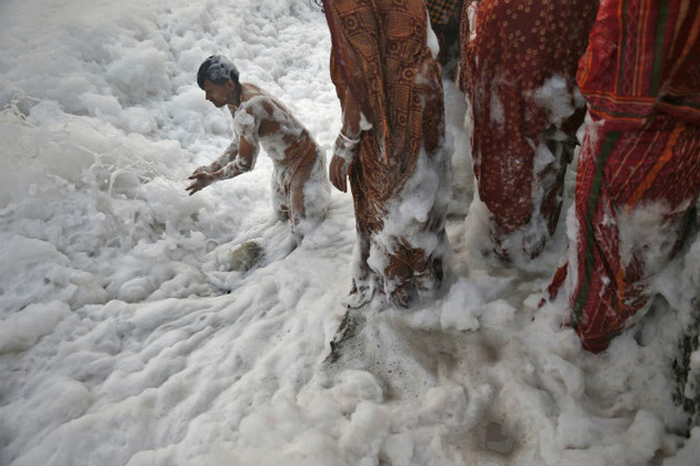 © Ahmad Masood/Reuters 
Индуисты во время обряда поклонения Сурье во время фестиваля Чат Пуджа в загрязненных водах реки Джамна в Нью-Дели