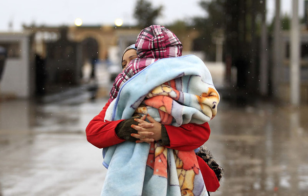 Тунисская женщина с ребенком на границе, бежавшая из Ливии обратно в Тунис.