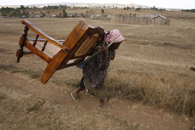 Женщина уносит мебель с места боя двух враждующих племен, окраина Моло, Найроби.