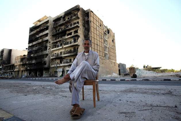 Мужчина на улице, разрушенной в ходе боев между повстанцами и силами Каддафи, Триполи.