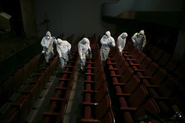 Сотрудники театра дезинфицируют кресла в зрительном зале. Южная Корея © Kim Hong-Ji—Reuters