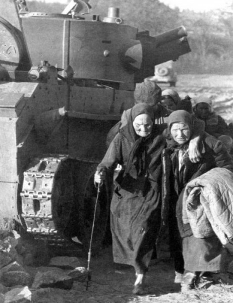 Советские беженцы идут мимо брошенного танка БТ-7А. Июнь 1941 г.