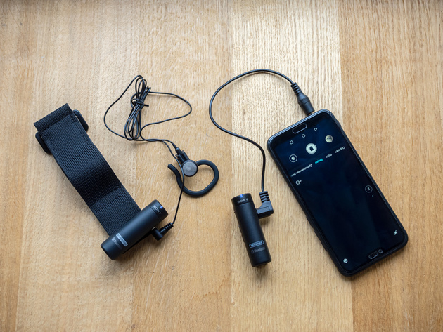 Слева: передатчик с петлёй на липучке и моно-наушником. Справа: ресивер, подключённый кабелем через выход для наушников к смартфону.